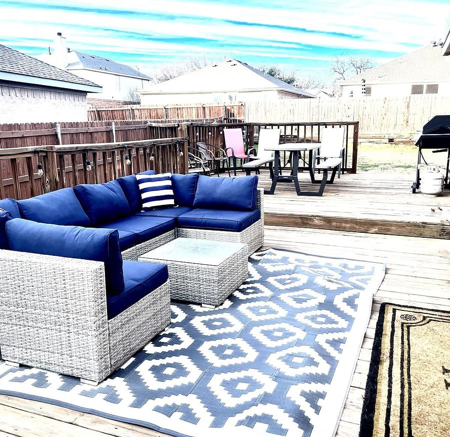 Backyard deck with sectional seating, dining table, and grill