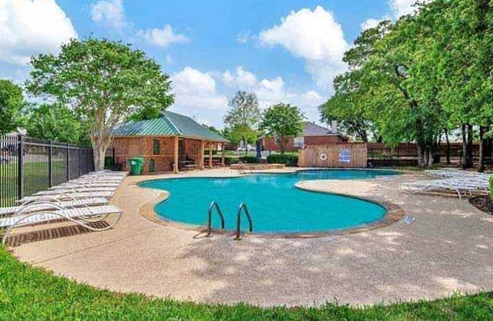 Seasonal subdivision pool with lounge chairs and trees